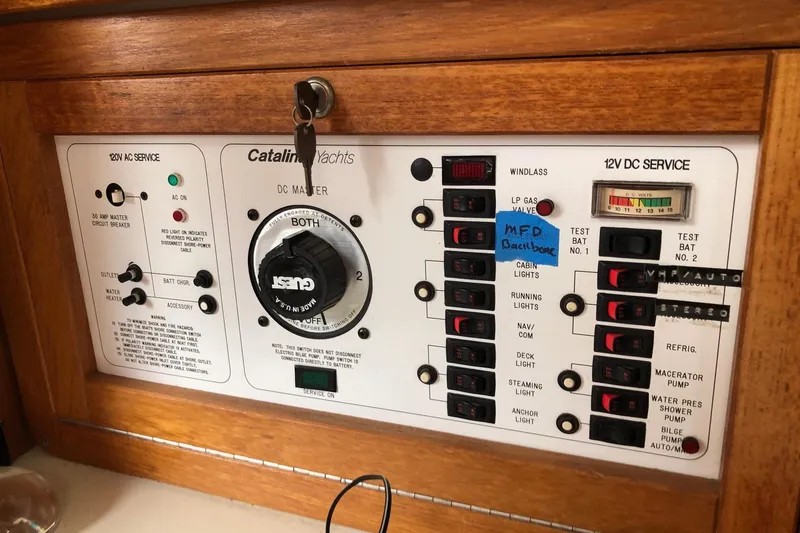 Slide: The Image of Control panel of a 1998 Catalina 320 yacht with various switches and indicators. - 30