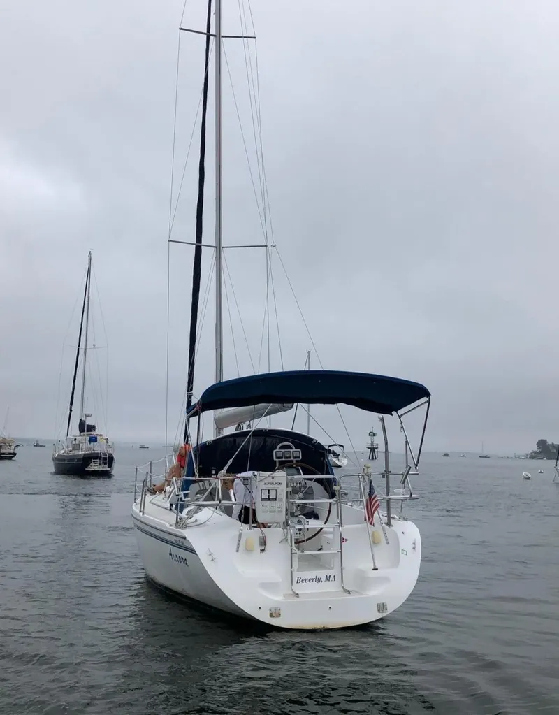 Slide: The Image of 1998 Catalina 320 sailboat docked under cloudy skies. - 6