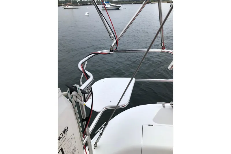 Slide: The Image of 1998 Catalina 320 sailboat stern view with stainless steel railings on calm water. - 9