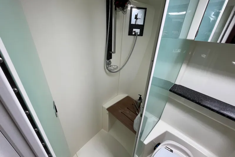 Slide: The Image of Shower area in 2015 Monterey 415 Sport Yacht with modern fixtures and wooden bench. - 26