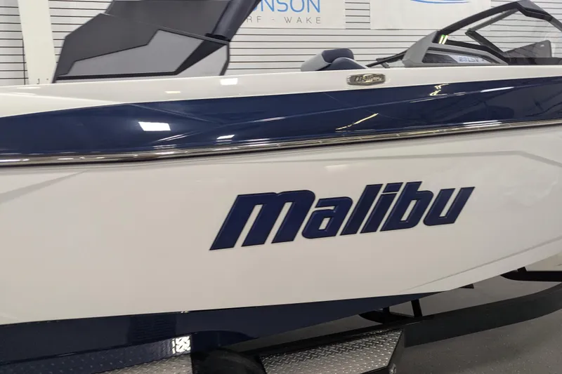Slide: The Image of 2026 Malibu Wakesetter 23 LSV boat, white and blue design, displayed indoors. - 4