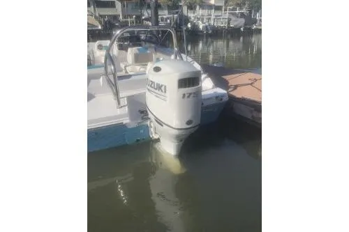Slide: The Image of 2025 Hurricane SunDeck 2050 OB boat with Suzuki outboard motor docked in marina. - 4