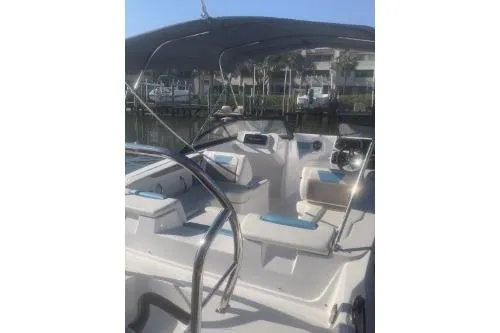 Slide: The Image of 2025 Hurricane SunDeck 2050 OB boat interior with seating and canopy in marina setting. - 6