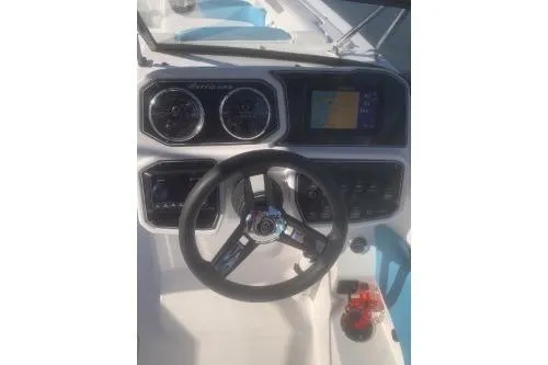 Slide: The Image of 2025 Hurricane SunDeck 2050 OB boat dashboard with steering wheel and navigation display. - 7
