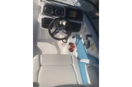 Slide: The Image of 2025 Hurricane SunDeck 2050 OB boat cockpit with steering wheel and control panel. - 9