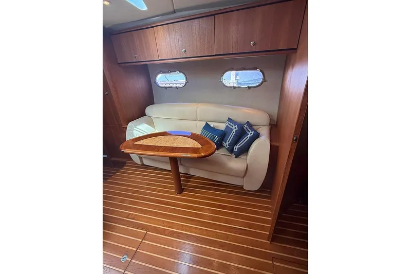 Slide: The Image of 2008 Tiara Yachts 3900 Sovran interior with wooden table, beige sofa, and decorative pillows. - 14