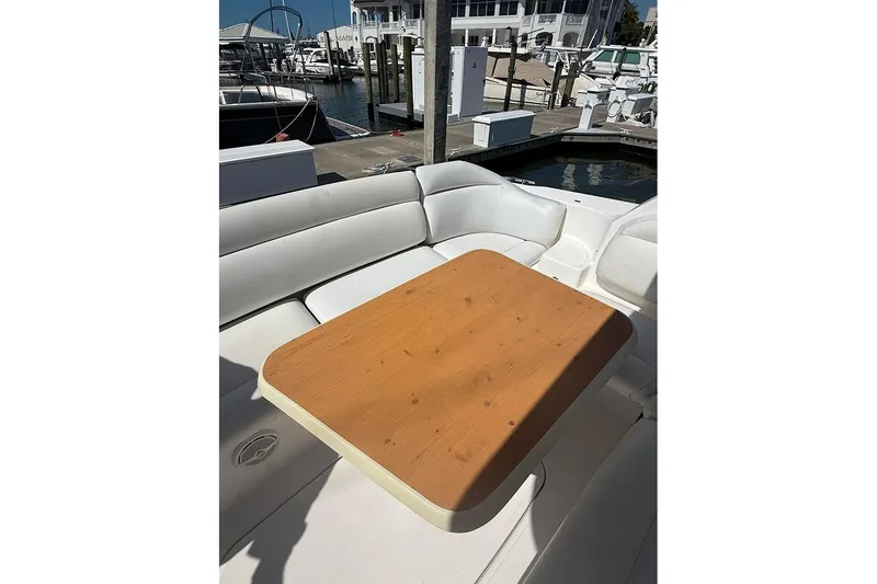 Slide: The Image of 2008 Tiara Yachts 3900 Sovran cockpit with wooden table and white seating at marina. - 42