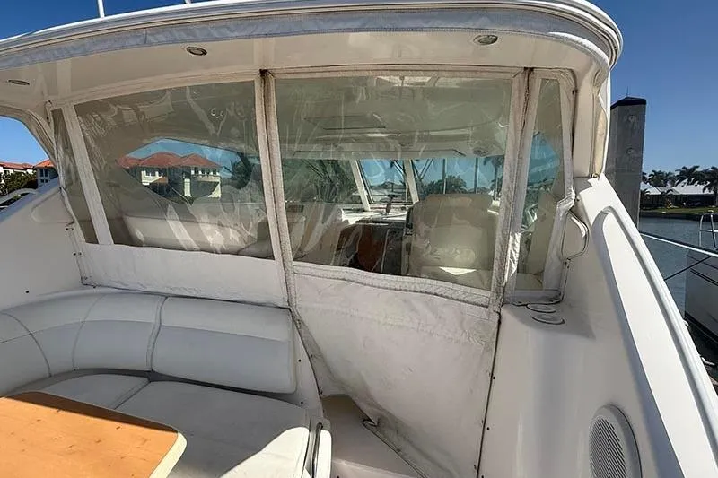 Slide: The Image of 2008 Tiara Yachts 3900 Sovran cockpit with white seating and clear enclosure. - 52