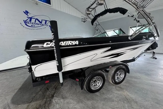 Slide: The Image of 2007 Calabria CAL AIR PRO V boat in showroom, black and white design, on a trailer. - 13