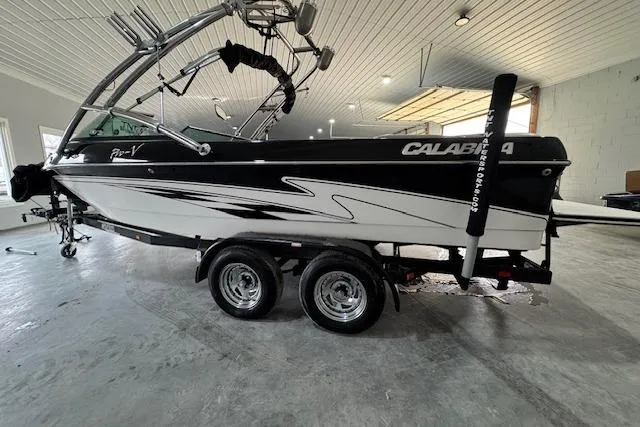 Slide: The Image of 2007 Calabria CAL AIR PRO V boat in a garage, black and white design, on a trailer. - 3