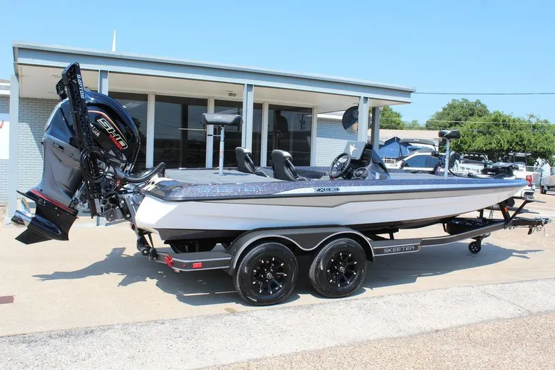 Slide: The Image of 2026 Skeeter ZXE21 boat with powerful outboard motor, parked outdoors. - 6