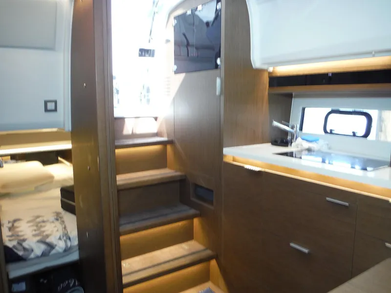 Slide: The Image of 2023 Jeanneau Leader 10.5 WA Series 2 interior with stairs, kitchenette, and sleeping area. - 36