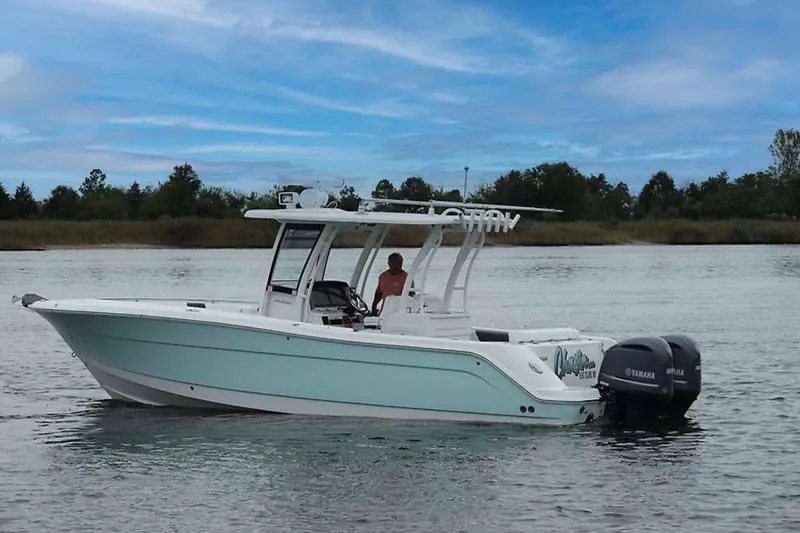 Slide: The Image of 2018 Robalo R302 Center Console boat on calm water with Yamaha engines. - 0