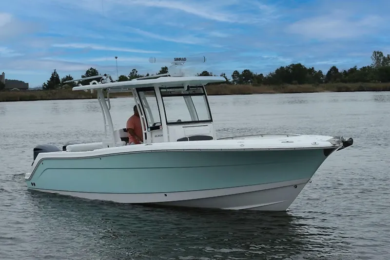 Slide: The Image of 2018 Robalo R302 Center Console boat on calm water under blue sky. - 1