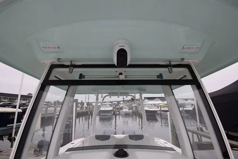 Slide: The Image of 2018 Robalo R302 Center Console boat at marina, showcasing helm and electronics. - 10