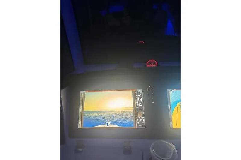 Slide: The Image of Dashboard of 2018 Robalo R302 Center Console with navigation screens at sunset. - 34