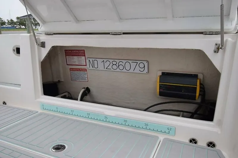 Slide: The Image of 2018 Robalo R302 Center Console storage compartment with equipment and measurement scale. - 36
