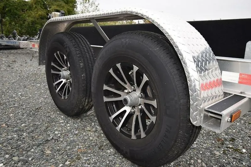 Slide: The Image of Trailer wheels for 2018 Robalo R302 Center Console on gravel surface. - 39