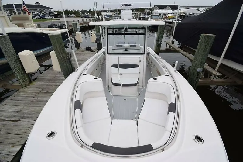 Slide: The Image of 2018 Robalo R302 Center Console boat docked at marina, featuring spacious seating and modern design. - 4