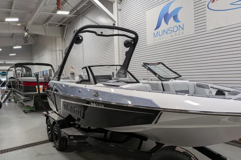 Slide: The Image of 2026 Malibu Wakesetter 20 VTX boat in showroom, sleek design, Munson Surf-Wake signage. - 4