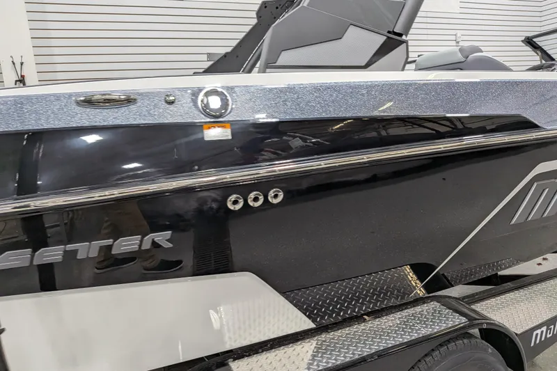 Slide: The Image of 2026 Malibu Wakesetter 20 VTX boat, sleek black design, displayed indoors. - 6