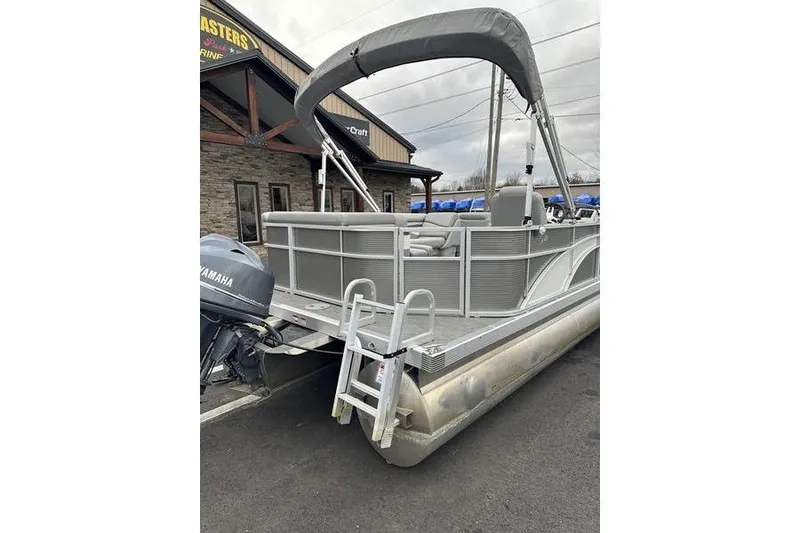 Slide: The Image of 2023 Bennington 21 SL pontoon boat with Yamaha motor, parked outside a building. - 12