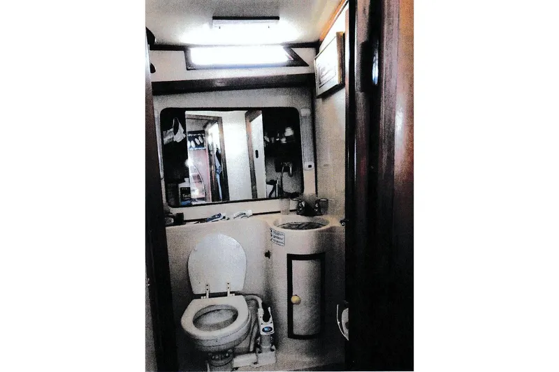 Slide: The Image of 1984 President D/C Motoryacht bathroom with toilet, sink, and mirror. - 14