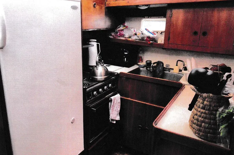 Slide: The Image of 1984 President D/C Motoryacht kitchen with stove, sink, and wooden cabinets. - 5