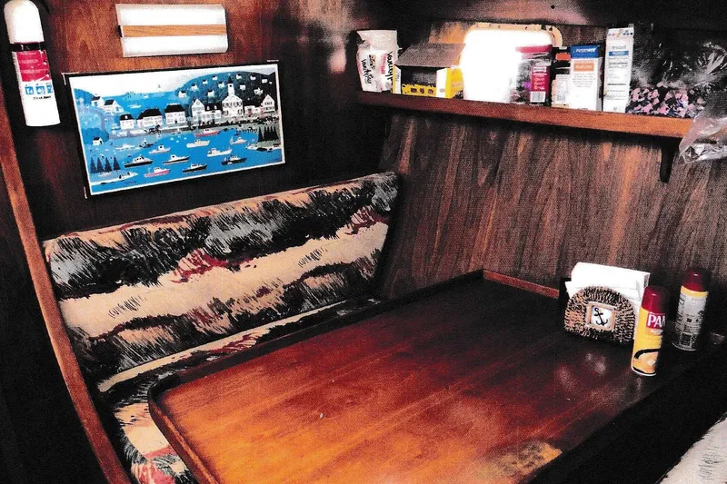 Slide: The Image of Cozy 1984 President D/C Motoryacht interior with wooden table, cushioned seating, and nautical decor. - 6