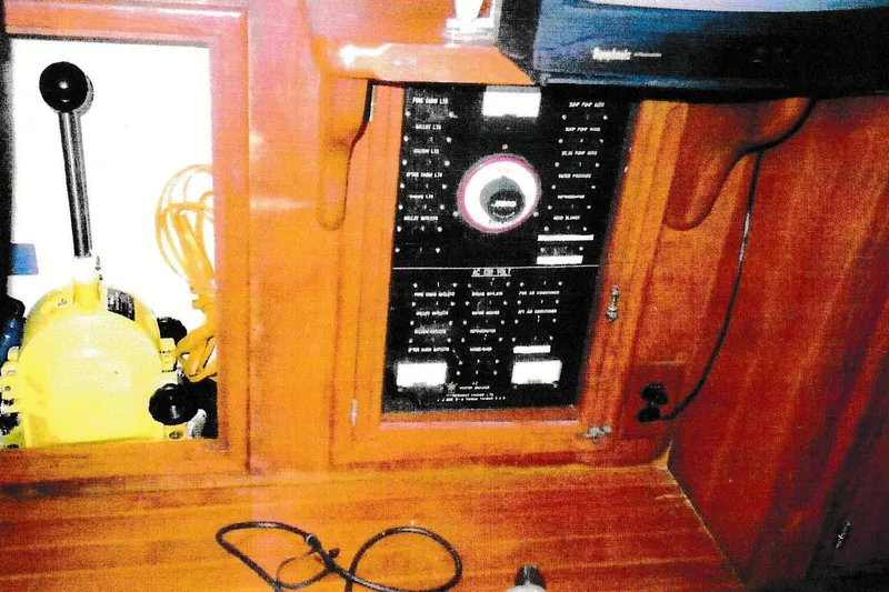 Slide: The Image of 1984 President D/C Motoryacht/Trawler control panel with wooden cabinetry and electrical components. - 9