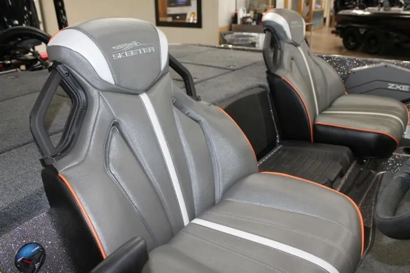 Slide: The Image of 2026 Skeeter ZXE21 boat interior with sleek gray seats and orange accents. - 5