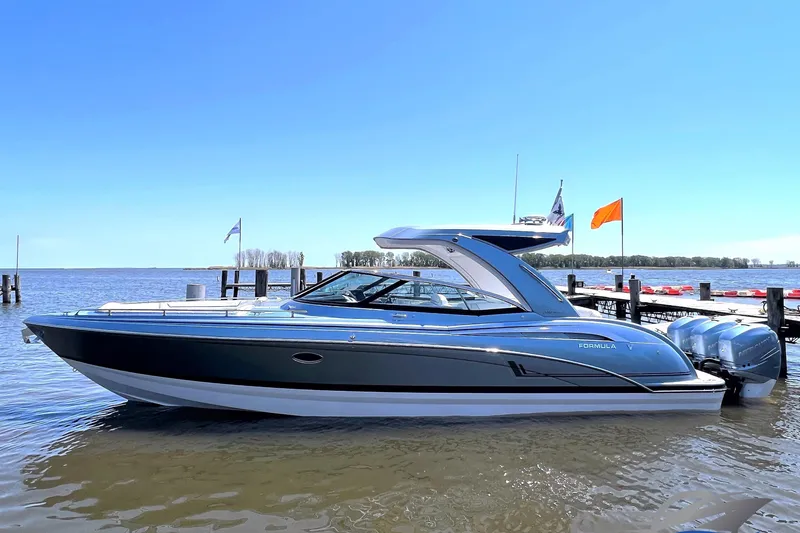 Slide: The Image of 2022 Formula 350 Crossover Bowrider boat docked on a sunny day. - 0