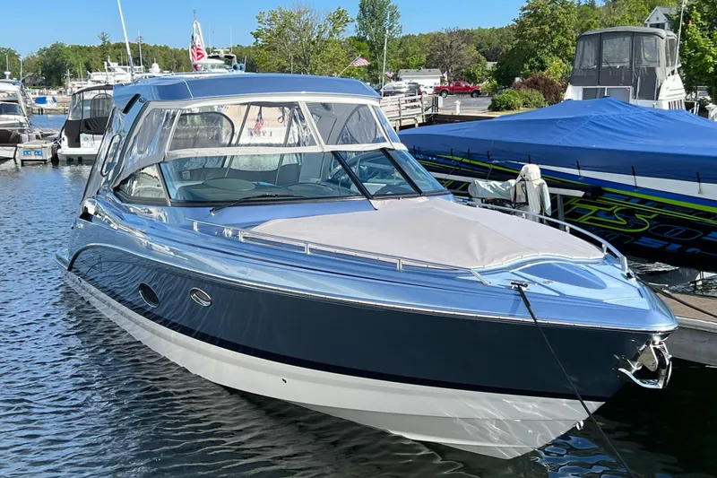 Slide: The Image of 2022 Formula 350 Crossover Bowrider docked at marina, sleek design, blue and white exterior. - 2