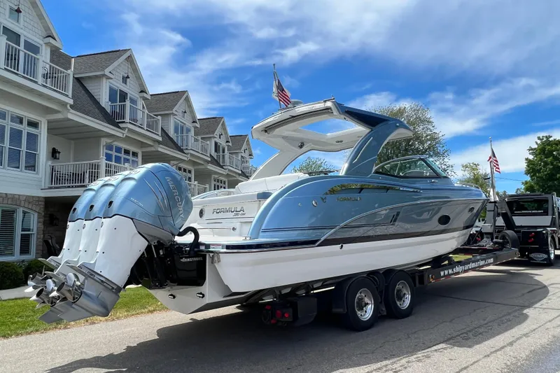 Slide: The Image of 2022 Formula 350 Crossover Bowrider on trailer, parked near residential buildings. - 3