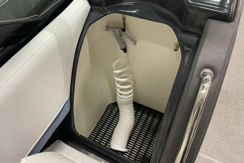 Slide: The Image of 2022 Formula 350 Crossover Bowrider storage compartment with coiled hose and handle. - 30