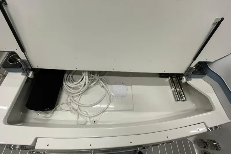 Slide: The Image of 2022 Formula 350 Crossover Bowrider storage compartment with coiled rope and sleek design. - 52