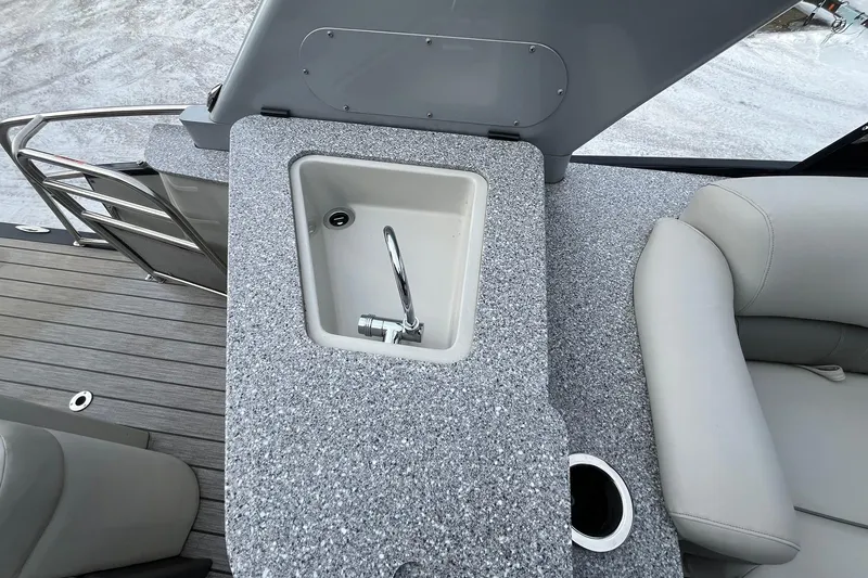 Slide: The Image of 2018 Avalon Excalibur Elite boat interior with sink and seating area. - 16