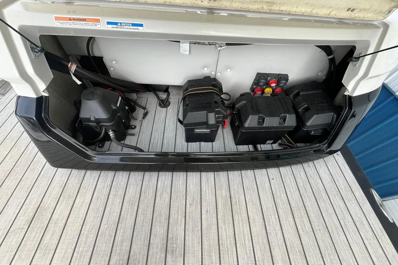 Slide: The Image of 2018 Avalon Excalibur Elite Windshield boat battery compartment with wiring and components. - 19
