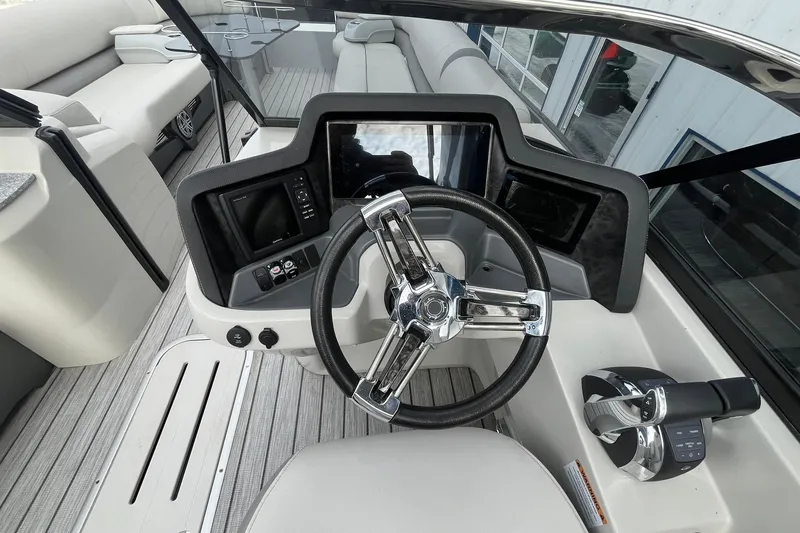 Slide: The Image of 2018 Avalon Excalibur Elite Windshield boat dashboard with steering wheel and controls. - 24