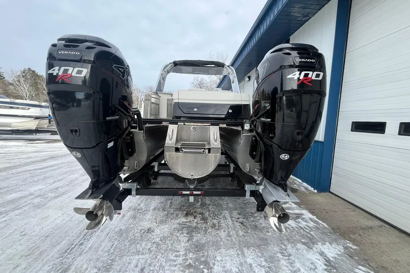 Slide: The Image of 2018 Avalon Excalibur Elite Windshield boat with dual Mercury 400R engines, parked outdoors. - 3