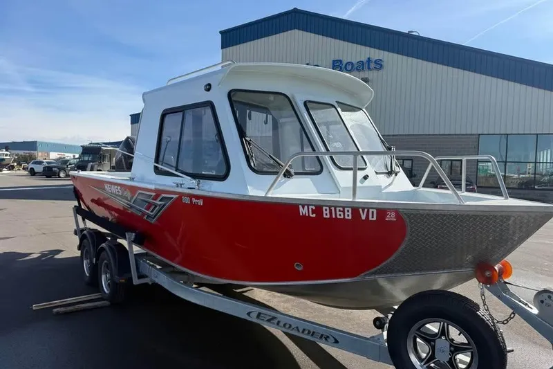 Slide: The Image of 2025 Hewescraft 200 ProV ET Hardtop boat on trailer, parked outside a building. - 2