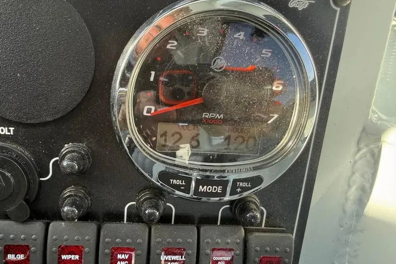 Slide: The Image of Control panel of 2025 Hewescraft 200 ProV ET Hardtop boat, showing RPM gauge and switches. - 23