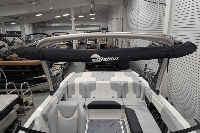 Slide: The Image of 2026 Malibu Wakesetter 21 LX interior with sleek seating and wakeboard tower in showroom. - 17