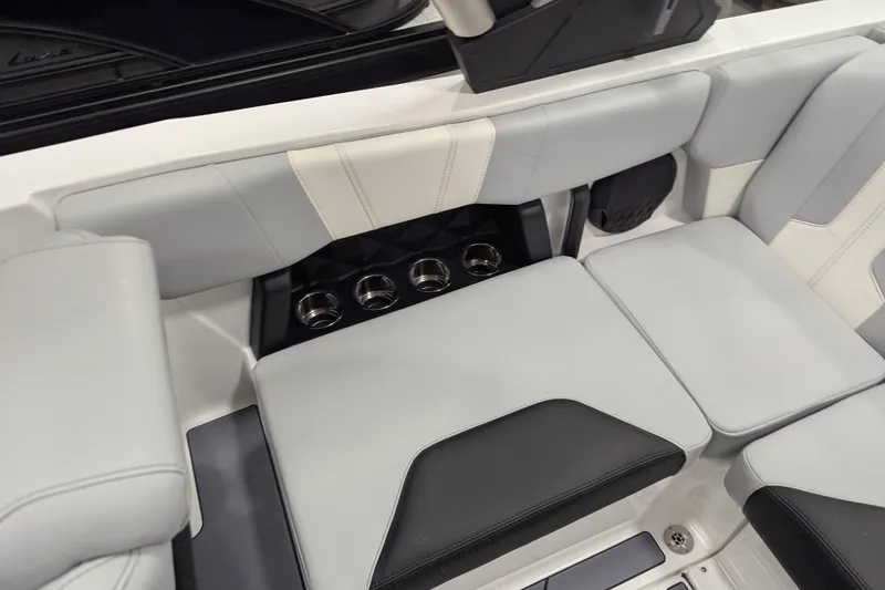 Slide: The Image of 2026 Malibu Wakesetter 21 LX interior seating with cup holders, featuring sleek gray and black upholstery. - 8