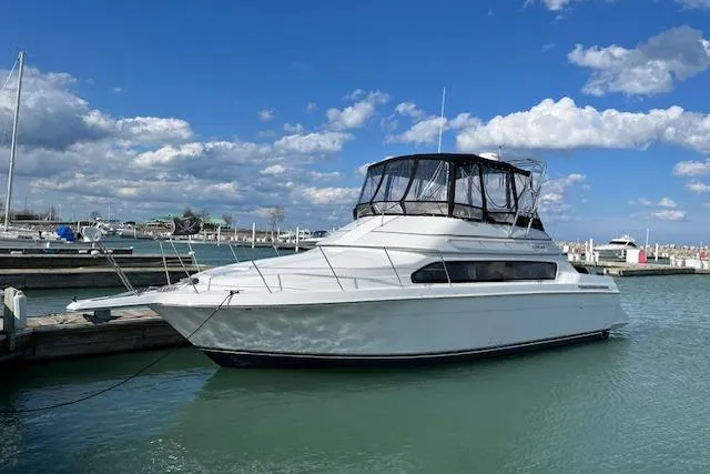 The Image of 1999 Carver 380 Santego yacht docked in a marina under a blue sky. - 0