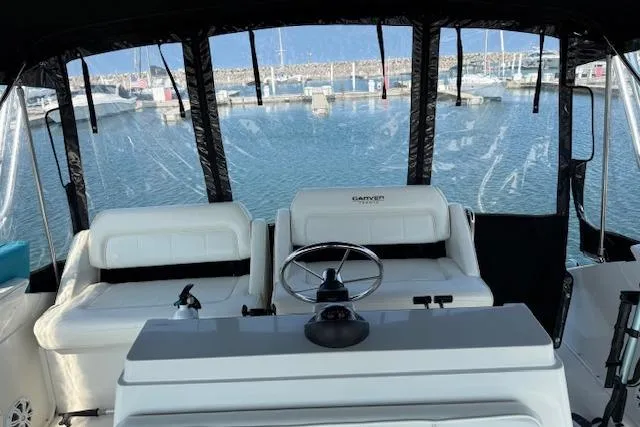 Slide: The Image of 1999 Carver 380 Santego yacht interior with steering wheel, docked at marina. - 10