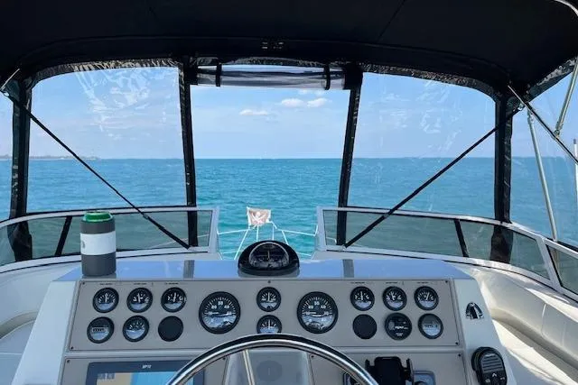 Slide: The Image of 1999 Carver 380 Santego yacht helm with ocean view, clear skies, and navigational instruments. - 3