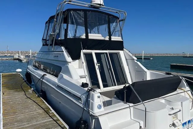 Slide: The Image of 1999 Carver 380 Santego yacht docked at marina under clear blue sky. - 6