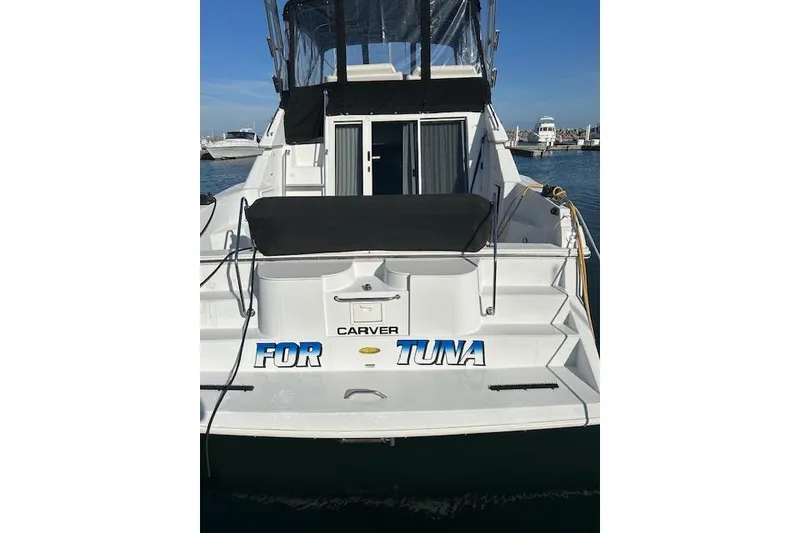 Slide: The Image of 1999 Carver 380 Santego boat docked, rear view with "FOR TUNA" text. - 7
