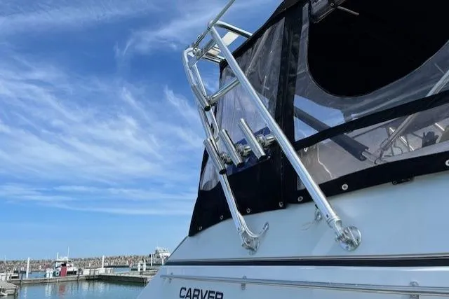 Slide: The Image of 1999 Carver 380 Santego yacht docked under a clear blue sky. - 8